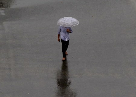 <p>Chennai: A man shields himself with an umbrella during rains, in Chennai on Oct 17, 2019. </p>
