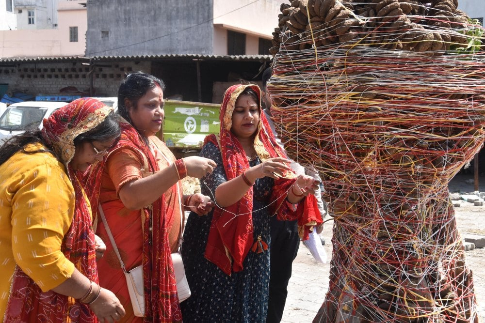 <p>Women perform rituals by tying sacred thread and offering prayer to ‘Holika’ on the eve of the festival of colours ‘Holi’ in Ranchi, Jharkhand on Sunday, March 24, 2024. Holi marks…